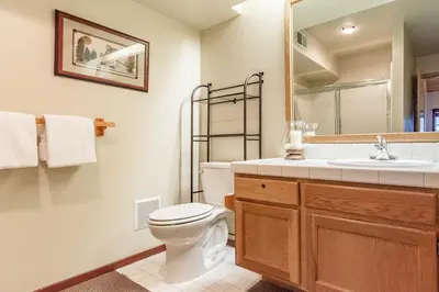 a bathroom with a toilet and a sink and a mirror at Snowcreek IV 598 in Mammoth Lakes