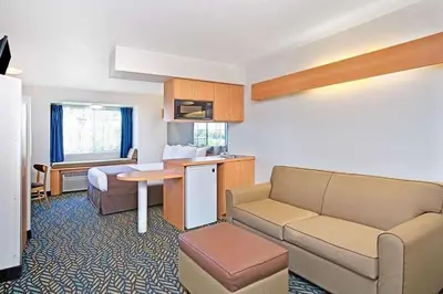 a small hotel room with a bed and a couch at Microtel Inn & Suites, Morgan Hill in Morgan Hill