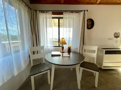 a table and chairs in a room with a window at Sierra Mountain Lodge - Vacation Rentals - Yosemite in Ahwahnee