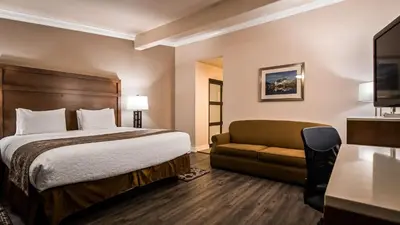 a hotel room with a bed and a couch at Best Western Bishop Lodge in Bishop