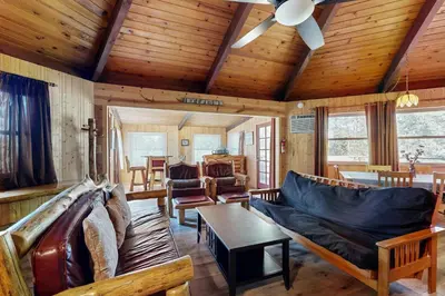 a living room with a couch and a table at Rustic Retreat in Groveland