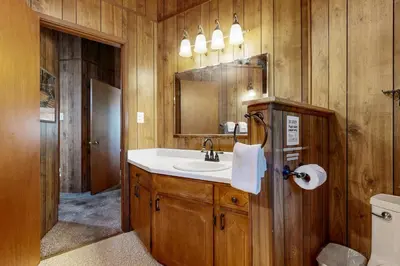 a bathroom with a sink and a mirror and a toilet at Rustic Retreat in Groveland