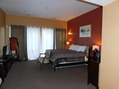 a hotel room with a bed and a chair at Freeport Wine Country Inn in Freeport