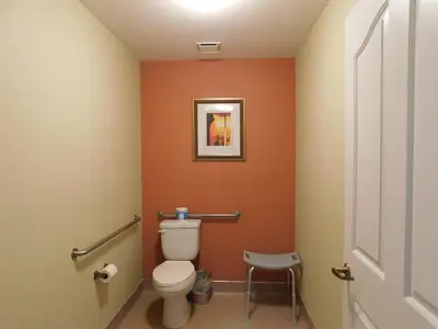 a bathroom with a toilet and a picture on the wall at Freeport Wine Country Inn in Freeport