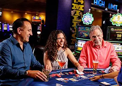 three people sitting at a poker table in a casino at Bally's Lake Tahoe Casino Resort in Stateline