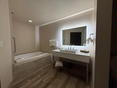 a bathroom with a tub and a sink and a mirror at Bally's Lake Tahoe Casino Resort in Stateline