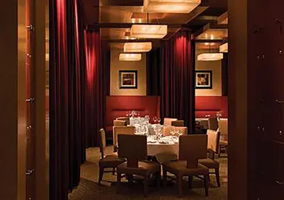 a dining room with a table and chairs and red curtains at Bally's Lake Tahoe Casino Resort in Stateline