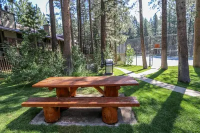 a wooden picnic table sitting in the grass at Sunshine Village #158 in Mammoth Lakes