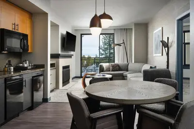 a kitchen and a living room with a table and chairs at The Westin Monache Resort, Mammoth in Mammoth Lakes