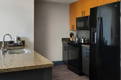 a kitchen with a black refrigerator and a sink at The Westin Monache Resort, Mammoth in Mammoth Lakes