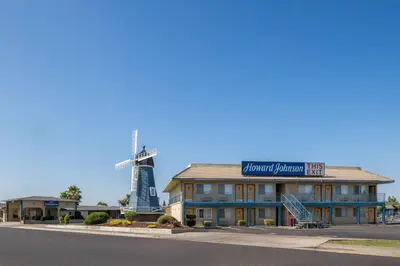 a building with a windmill in the background at Howard Johnson by Wyndham Modesto Ceres in Ceres