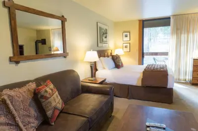 a bedroom with a bed and a couch and a mirror at 3160 Aspen Grove in Truckee