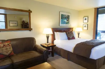 a bedroom with a bed and a couch and a chair at 3160 Aspen Grove in Truckee