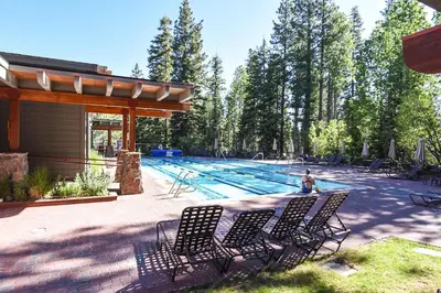 a pool with chairs and a person sitting in front of it at 3130 Aspen Grove in Truckee