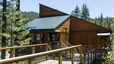 a large wooden cabin with a staircase leading up to it at 3174 Aspen Grove in Truckee