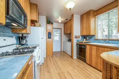 a kitchen with a white refrigerator and wooden cabinets at Sparrow Cove in Shaver Lake