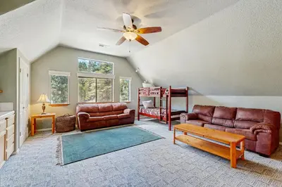 a living room with couches and a ceiling fan at The Rockin' Buffalo in Shaver Lake