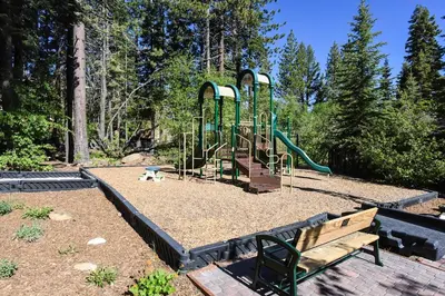 a park with a playground with a slide and a bench at 3159 Aspen Grove in Truckee