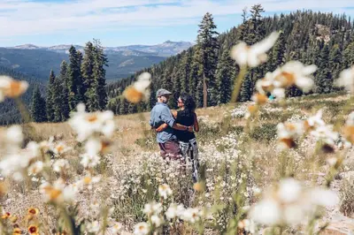 a man and woman standing in a field of flowers at 3159 Aspen Grove in Truckee