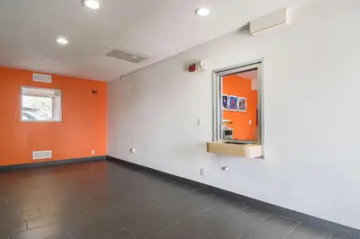 an empty room with orange walls and a mirror at Motel 6 Lost Hills / Buttonwillow Racetrack in Lost Hills