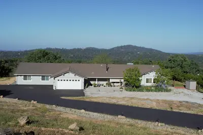 a large white house with a garage at Yosemite Foothill Retreat in Coarsegold