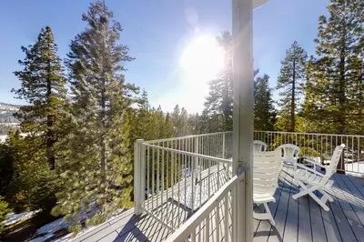 a porch with two white chairs and the sun at Eagles Nest Condo #88 in Lakeshore