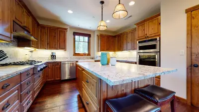 a large kitchen with wooden cabinets and a large island at Gray Stone Condo #2110 in Mammoth Lakes