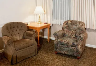 a room with a chair and a chair and a desk at June Lake Motel in June Lake