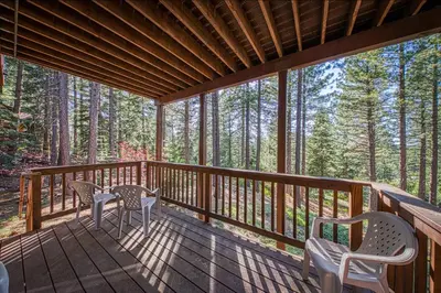 a screened in porch with two chairs and a table at Elegant Pine in South Lake Tahoe