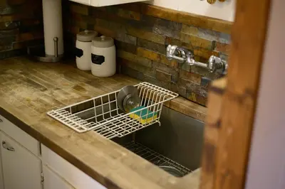 a kitchen sink with a dish drying rack in it at Lake Front Cabins in June Lake
