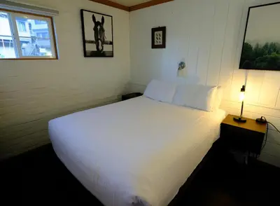 a large white bed in a room with a window at Lake Front Cabins in June Lake