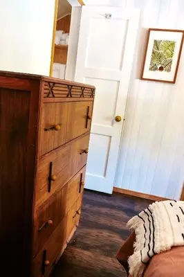a bedroom with a wooden dresser next to a bed at Lake Front Cabins in June Lake