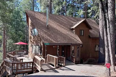 a cabin in the woods with a porch and benches at Mitthas Tapovan in Arnold