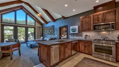 a kitchen with wooden cabinets and a living room at Zalanta 319 in South Lake Tahoe