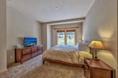a bedroom with a bed with a dresser and a television at R101 Timber Ridge in Kirkwood