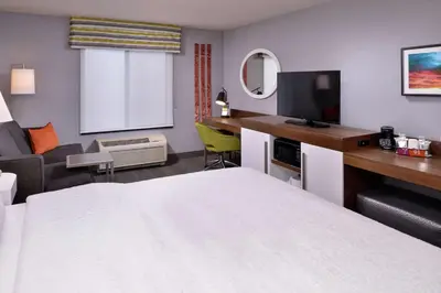 a hotel room with a bed and a desk with a television at Hampton Inn & Suites Carson City in Carson City