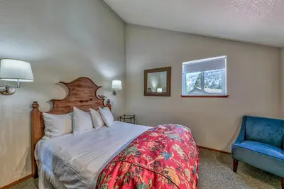 a bedroom with a bed and a blue chair and a window at 3302 Sun Meadows in Kirkwood