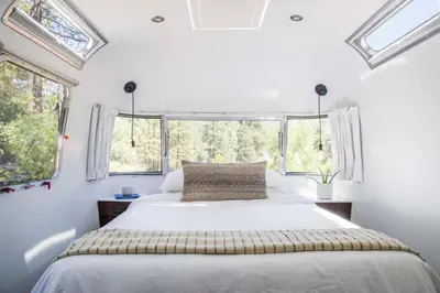 a bedroom with a large bed and windows at AutoCamp Yosemite in Midpines