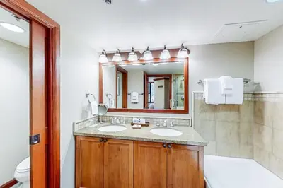 a bathroom with two sinks and a large mirror at Resort at Squaw Creek 808 in Olympic Valley