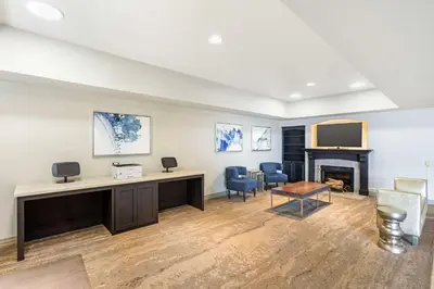 a room with a desk and chairs and a fireplace at Best Western Plus Villa Del Lago Inn Patterson in Patterson
