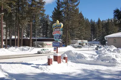 a snow covered street with a sign in the middle at Crown Motel in Kings Beach