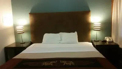 a bedroom with a bed with two lamps and a phone at The Gold Lodge in Sonora