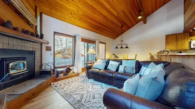 a living room with a leather couch and a fireplace at Tennis Village 14 Townhouse in Mammoth Lakes