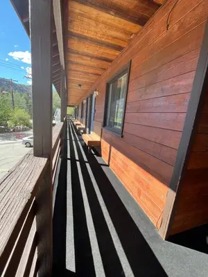 a wooden building with benches on the side of it at June Lake Villager in June Lake