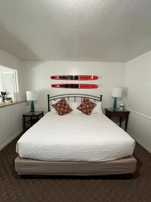 a bedroom with a white bed with two lamps and two tables at June Lake Villager in June Lake