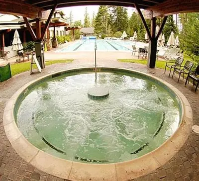 a swimming pool with a hot tub in the middle at Luxury Lodgepole Home at Northstar in Truckee