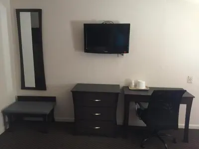 a bedroom with a desk and a tv on the wall at Portal Motel in Lone Pine