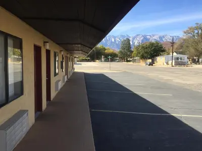 a shadow of a building with mountains in the background at Portal Motel in Lone Pine