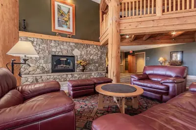 a living room with leather furniture and a stone fireplace at Sunstone 326 in Mammoth Lakes