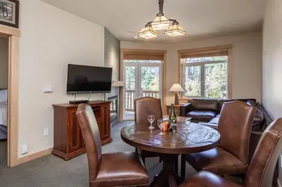 a living room with a table and a tv at Sunstone 326 in Mammoth Lakes
